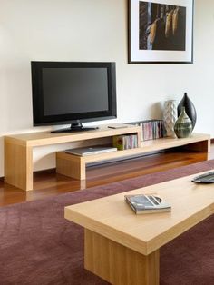 a living room with a tv, coffee table and other items on the floor in front of it