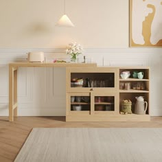 a wooden table sitting next to a white rug on top of a hard wood floor