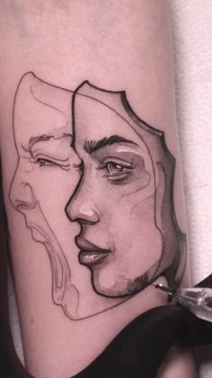 a woman's face with two faces drawn on her leg, in black and white