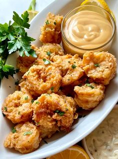 a white plate topped with fried food and dipping sauce