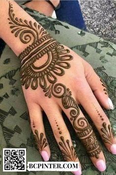 a woman's hand with henna tattoos on it