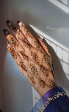 a woman's hand with henna tattoos on it