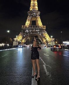 a woman standing in front of the eiffel tower