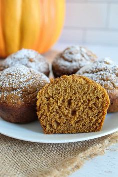 some muffins are on a plate with a pumpkin in the backgroud