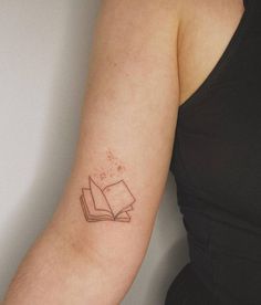 a woman with a book tattoo on her arm