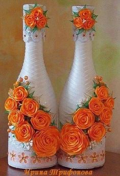 two white vases with orange flowers on them