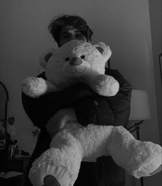 a man holding a large teddy bear in his arms