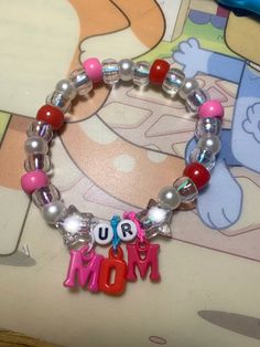 a bracelet with beads and charms that say mom on the front, and an i love you charm on the back