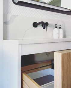 a bathroom sink under a mirror with soap and toothbrushes on the counter top