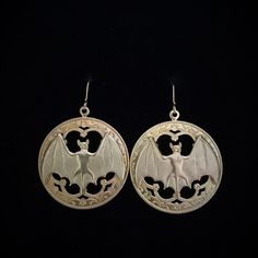 Large Gothic style hoops with a gold brass bat hang from a gold filled French hook earring. The stamped, raw brass hoops have great detail. These are kind of heavy since the 1.25 x .75 inch bats are cast brass. They also have nice detail including eyes, ears, muzzle and hatch marks on the wings. They drop to about 2 inches. Please note that raw brass will oxidize over time, diminishing the brightness and giving it a natural antique darkening of the gold color. This piece of jewelry is sent in a Steampunk Gold Jewelry For Halloween, Handmade Gothic Gold Earrings, Handmade Gold Witchy Jewelry, Handmade Witchy Gold Jewelry, Gothic Brass Earrings Nickel Free, Gothic Gold Nickel-free Jewelry, Nickel-free Gold Gothic Jewelry, Gothic Gold Brass Earrings, Gold Gothic Brass Earrings