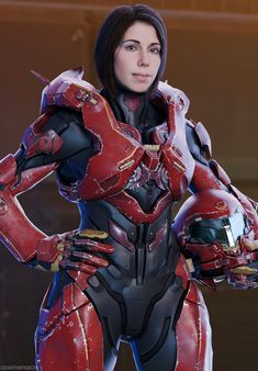 a woman dressed in red and black armor with her hands on her hips, posing for the camera