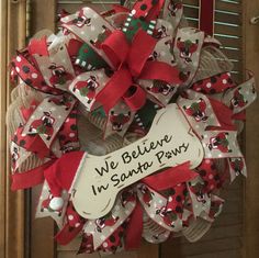 a wreath that says we believe i'm santa paws on it with red and white polka dots