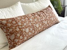 a brown and white pillow sitting on top of a bed