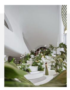 a woman standing in the middle of a room filled with plants