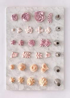 there are many different types of buttons on the marble board, including one with pink and white frosting