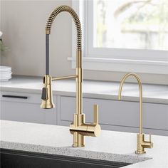 a kitchen sink with a faucet and gold faucet