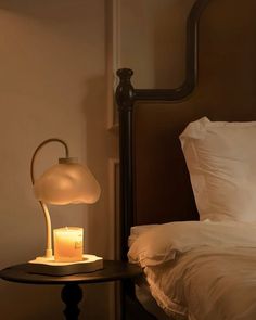 a lamp on a table next to a bed