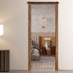 a living room with a sliding glass door that has beaded curtains on the side