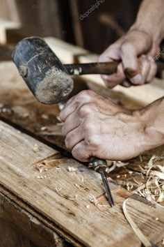 a man is working on woodworking with an old hammer and two hands holding tools