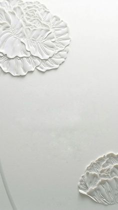 two white plates with designs on them sitting next to each other