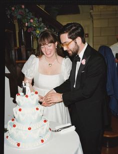 a bride and groom cutting their wedding cake