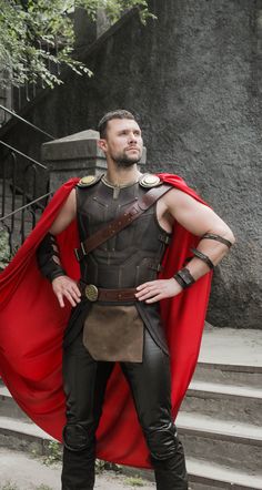 a man dressed in roman armor and cape standing on steps with his hands on his hips