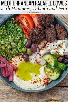 mediterranean falafel bowls with hummus, salad and feta on a wooden table