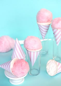 pink cupcakes in striped paper cones on a blue background with other dessert items