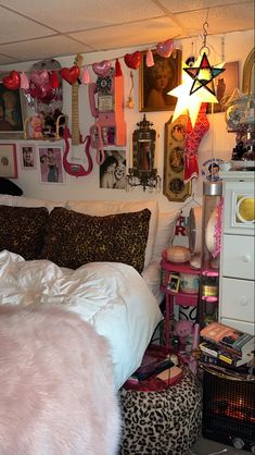 a bedroom decorated in pink and leopard print with lots of decorations on the wall above the bed