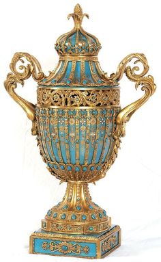 an ornate blue and gold urn is shown against a white background with the lid open