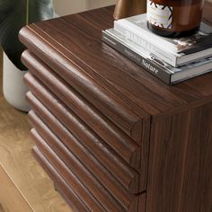 a wooden table with books and a jar on top