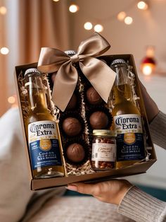 a person holding a box of beer and chocolates