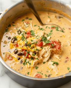 a pot filled with chicken and black bean soup on top of a white marble counter