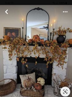 a fireplace decorated for fall with candles and pumpkins