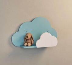 a toy dog sitting on top of a cloud shaped shelf in the shape of a teddy bear