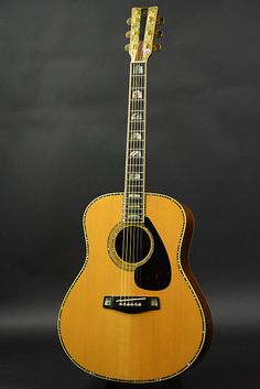 an acoustic guitar is shown against a black background