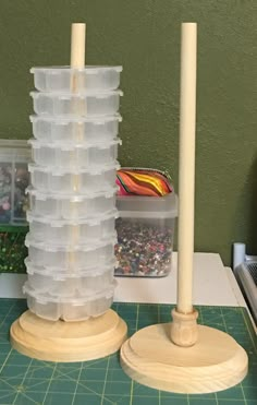 two plastic containers are stacked on top of each other near a candle and some crafting supplies