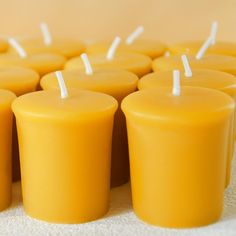 many yellow candles are lined up in rows