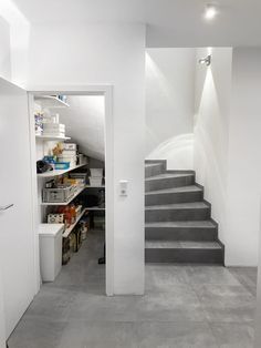 an empty room with stairs leading up to the second floor and storage area in it