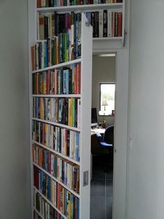 a book shelf filled with lots of books next to a wall full of bookshelves