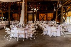 tables and chairs are set up in an old barn for a wedding or other function