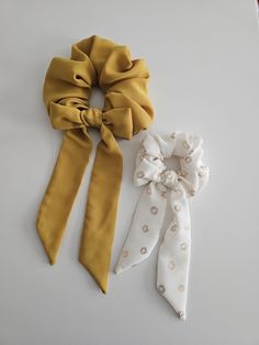 three scrunffle hair ties laid out on a white surface, one yellow and one white