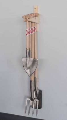 a wall mounted garden tool rack with gardening utensils hanging from it's sides