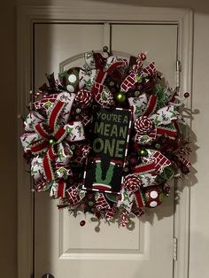 a christmas wreath on the front door with a sign that says you're meant to be one