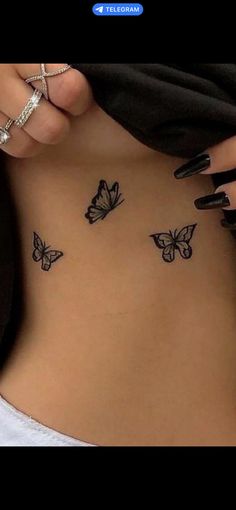 a woman's stomach with butterfly tattoos on her belly and the bottom part of her abdomen