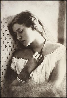 an old black and white photo of a woman in a wedding dress with her eyes closed