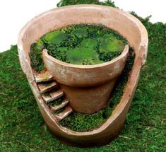 an old clay pot with moss growing in it's bottom and steps leading up to the top