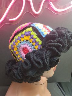 a mannequin head wearing a multicolored knitted hat