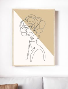 a drawing of a woman with flowers in her hair on a wall above a couch