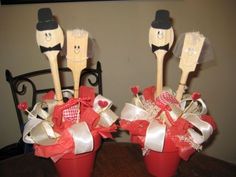 three wooden utensils in red buckets decorated with ribbon and bow on table